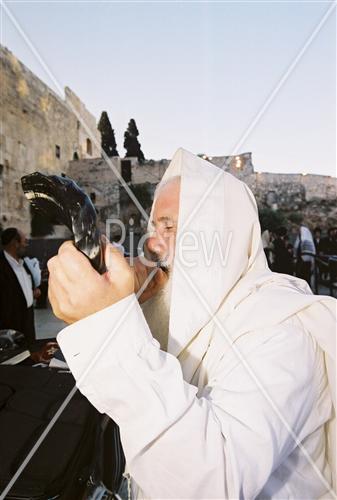 Man blowing Yemenite shofar