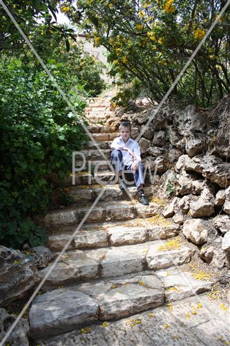 ילד יושב על מדרגות