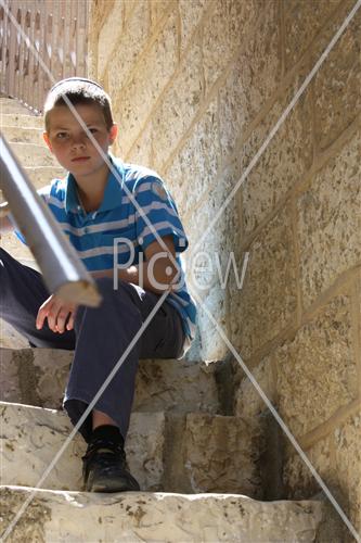 ילד יושב על מדרגות