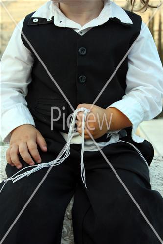 A child holding a Tzitziot