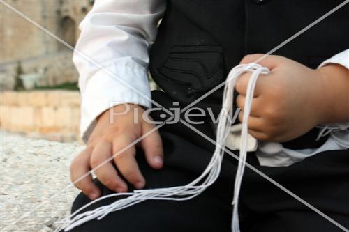 A child holding a Tzitziot