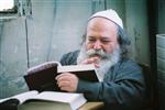 יהודי מבוגר לומד תורה בבית כנסת במאה שערים