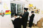 Father and Sons light Chanukah candles in the window