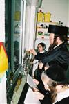 Father and Sons light Chanukah candles in the window