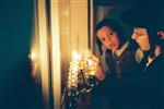 Father and Sons light Chanukah candles in the window