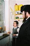 Father and Sons light Chanukah candles in the window