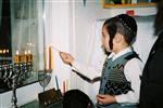 Father and Sons light Chanukah candles in the window