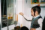 Father and Sons light Chanukah candles in the window