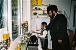 Father and Sons light Chanukah candles in the window