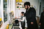 Father and Sons light Chanukah candles in the window