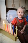 A child lights a menorah at the entrance facing the public domain