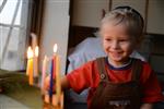 A child lights a menorah at the entrance facing the public domain