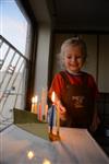 A child lights a menorah at the entrance facing the public domain