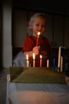 A child lights a menorah at the entrance facing the public domain