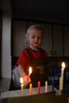 A child lights a menorah at the entrance facing the public domain