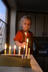 A child lights a menorah at the entrance facing the public domain
