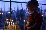 A child lights a menorah at the entrance facing the public domain