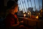 A child lights a menorah at the entrance facing the public domain