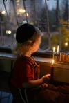 A child lights a menorah at the entrance facing the public domain