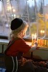 A child lights a menorah at the entrance facing the public domain