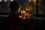 A child lights a menorah at the entrance facing the public domain