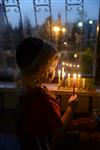 A child lights a menorah at the entrance facing the public domain