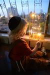 A child lights a menorah at the entrance facing the public domain