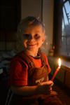 A child lights a menorah at the entrance facing the public domain