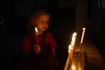 A child lights a menorah at the entrance facing the public domain