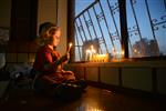 A child lights a menorah at the entrance facing the public domain