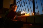 A child lights a menorah at the entrance facing the public domain