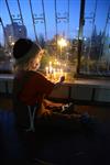 A child lights a menorah at the entrance facing the public domain