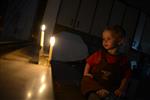 A child lights a menorah at the entrance facing the public domain