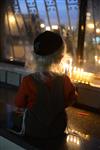 A child lights a menorah at the entrance facing the public domain