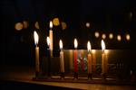 A child lights a menorah at the entrance facing the public domain