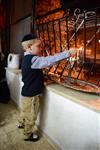 A child lights a menorah at the entrance facing the public domain