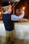 A child lights a menorah at the entrance facing the public domain