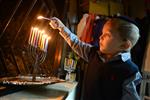 A child lights a menorah at the entrance facing the public domain