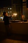 A child lights a menorah at the entrance facing the public domain