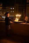 A child lights a menorah at the entrance facing the public domain