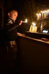 A child lights a menorah at the entrance facing the public domain