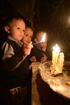 A child lights a menorah at the entrance facing the public domain