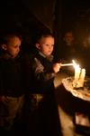 A child lights a menorah at the entrance facing the public domain