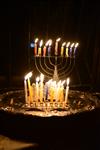 A child lights a menorah at the entrance facing the public domain