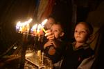 A child lights a menorah at the entrance facing the public domain