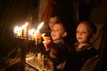 A child lights a menorah at the entrance facing the public domain