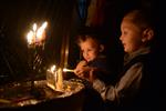 A child lights a menorah at the entrance facing the public domain