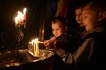 A child lights a menorah at the entrance facing the public domain