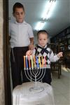 A child lights a menorah at the entrance facing the public domain