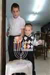 A child lights a menorah at the entrance facing the public domain